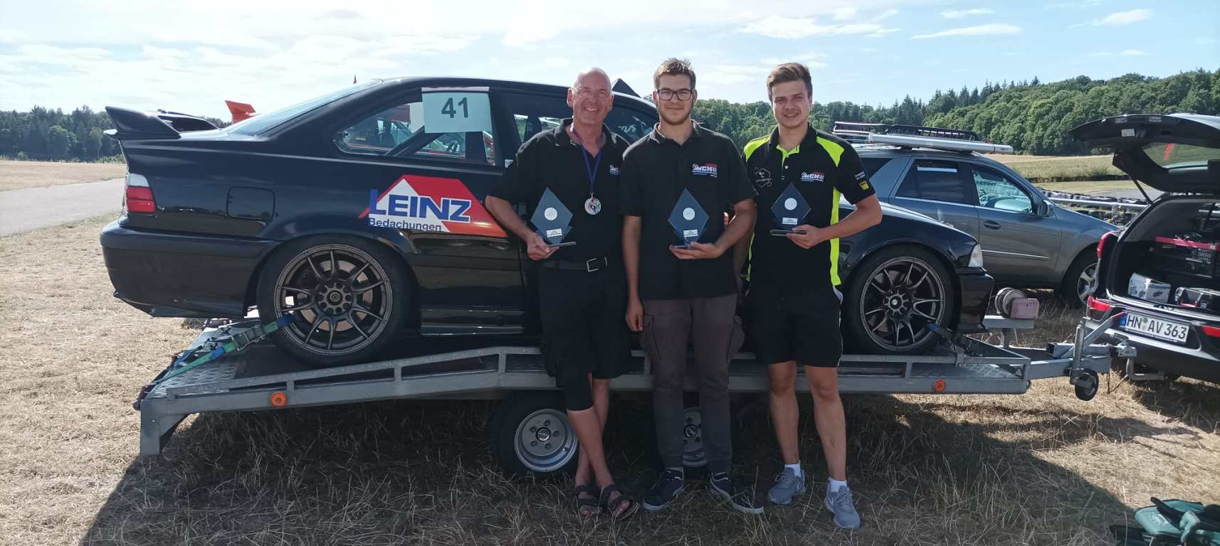 Andy Baier, Nico Chelminiacki und Marcel Pimpl (von links nach rechts) mit ihren Trophäen vor dem BMW M3 von Andy Baier